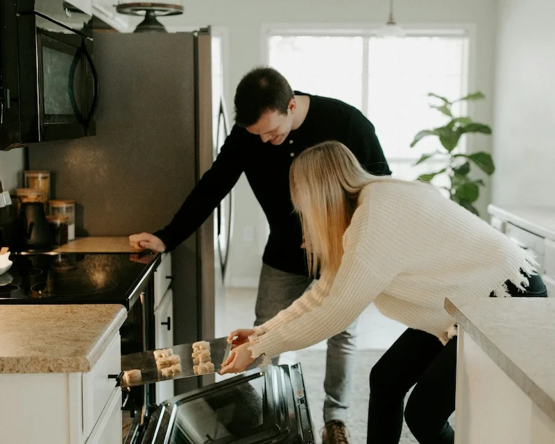 A man and woman baking in the kitchen